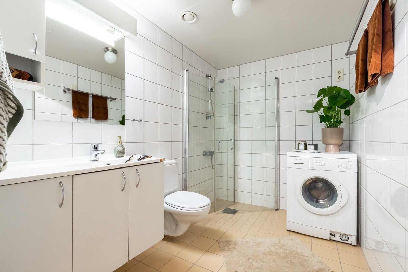 Lyst, flislagt bad med varme i gulv. Badet har opplegg for vaskemaskin samt plass til tørketrommel. Galleribilde