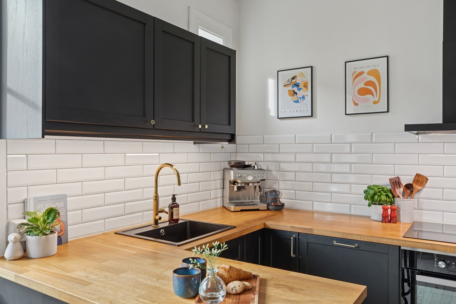 Det er lagt fliser over benken og det er en pen, svar vask med gullkran. Galleribilde