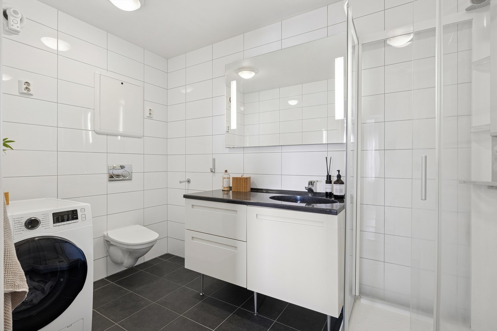 Flislagt baderom fra 2010 med vegghengt toalett, dusjkabinett, servant med god oppbevaringsplass og opplegg til vm! Galleribilde