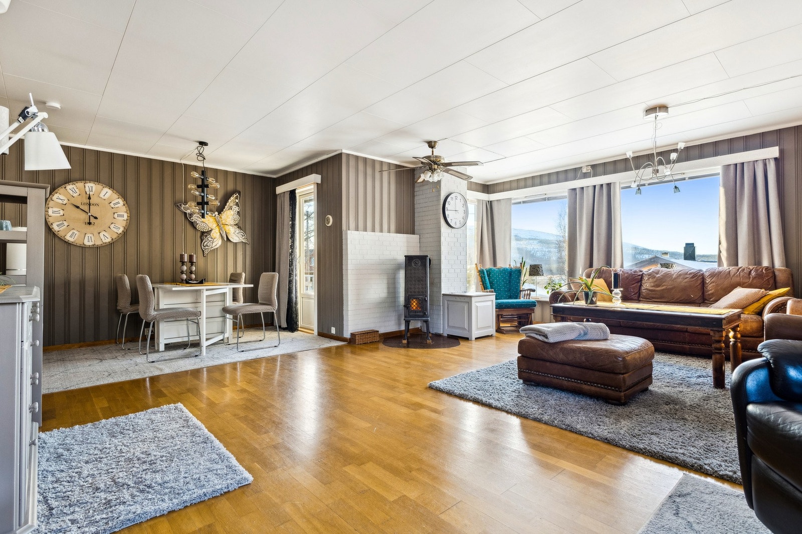 Stua har parkettgulv og malt trepanel på vegger. Galleribilde