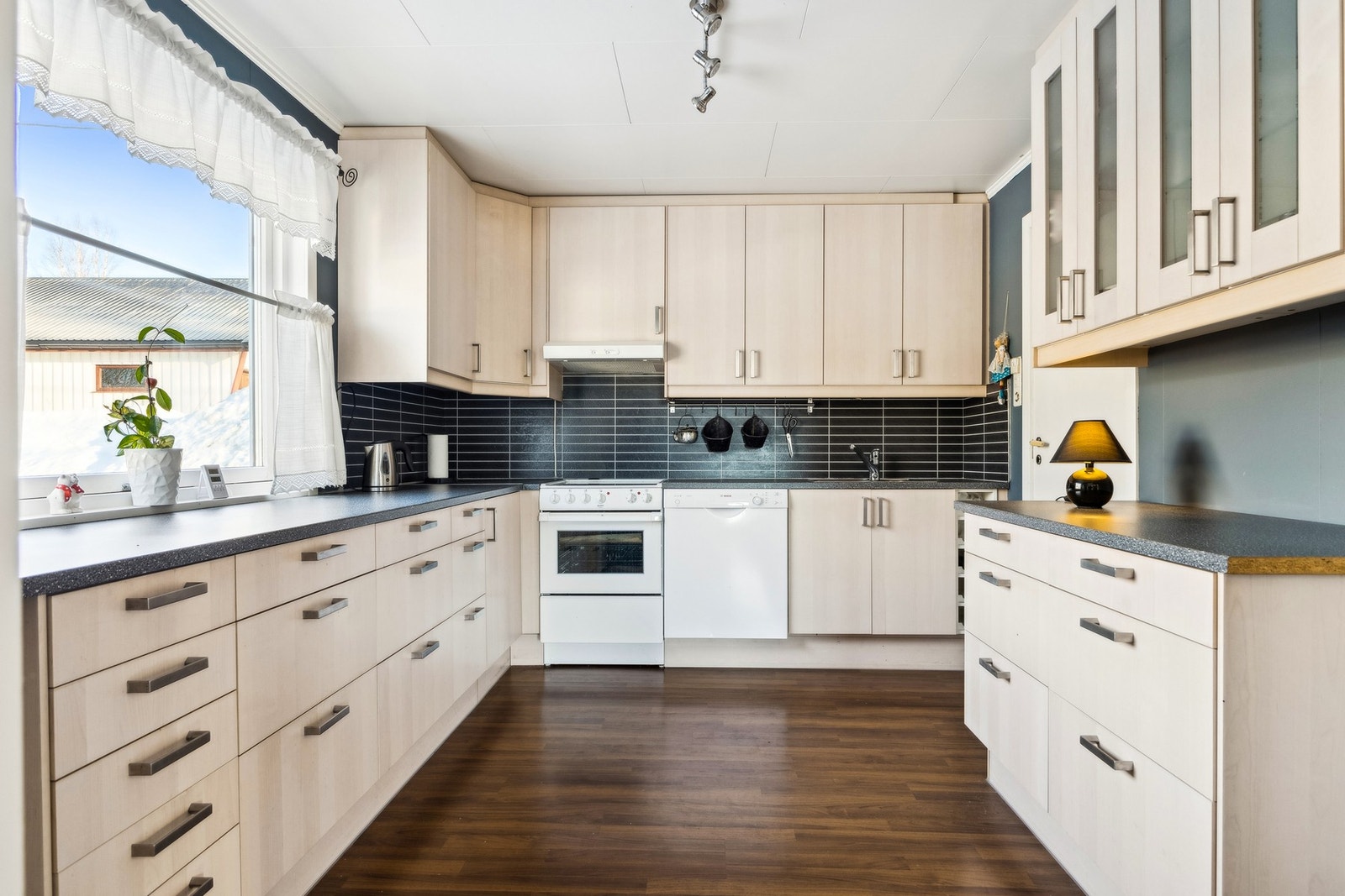 Lyst og praktisk kjøkken som har rikelig med oppbevaring. Galleribilde