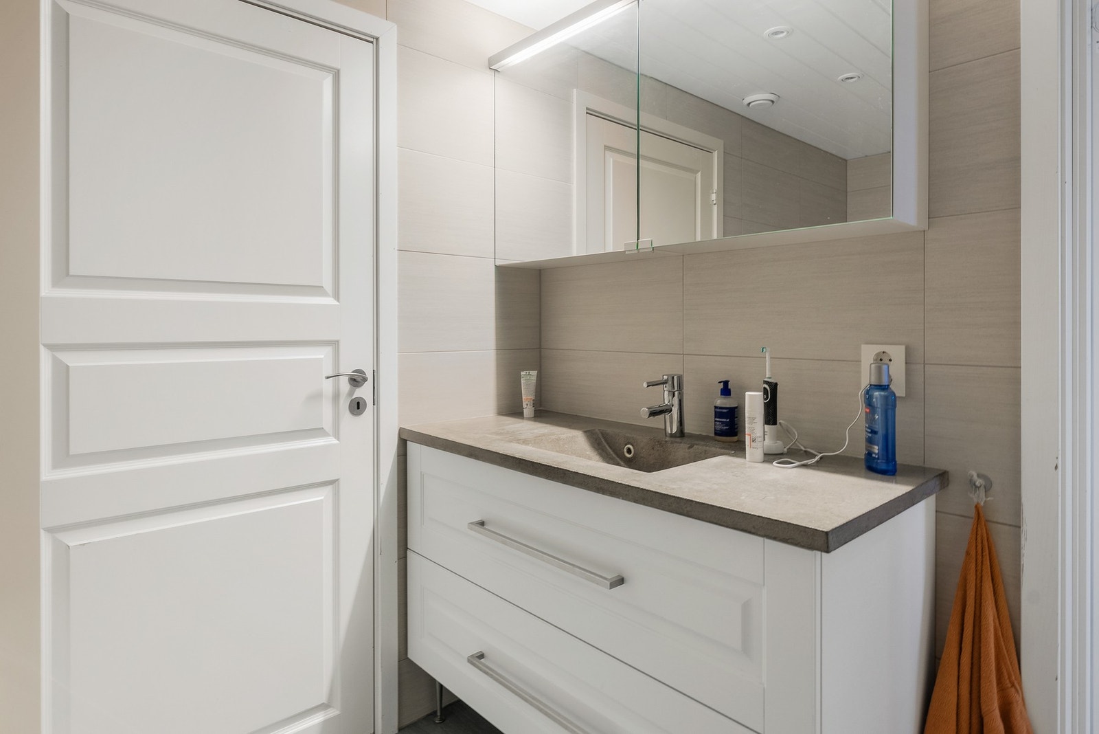 Gulvstående servantinnredning med speilskap med overlys. Badet inneholder badekar og gulvstående toalett. Galleribilde