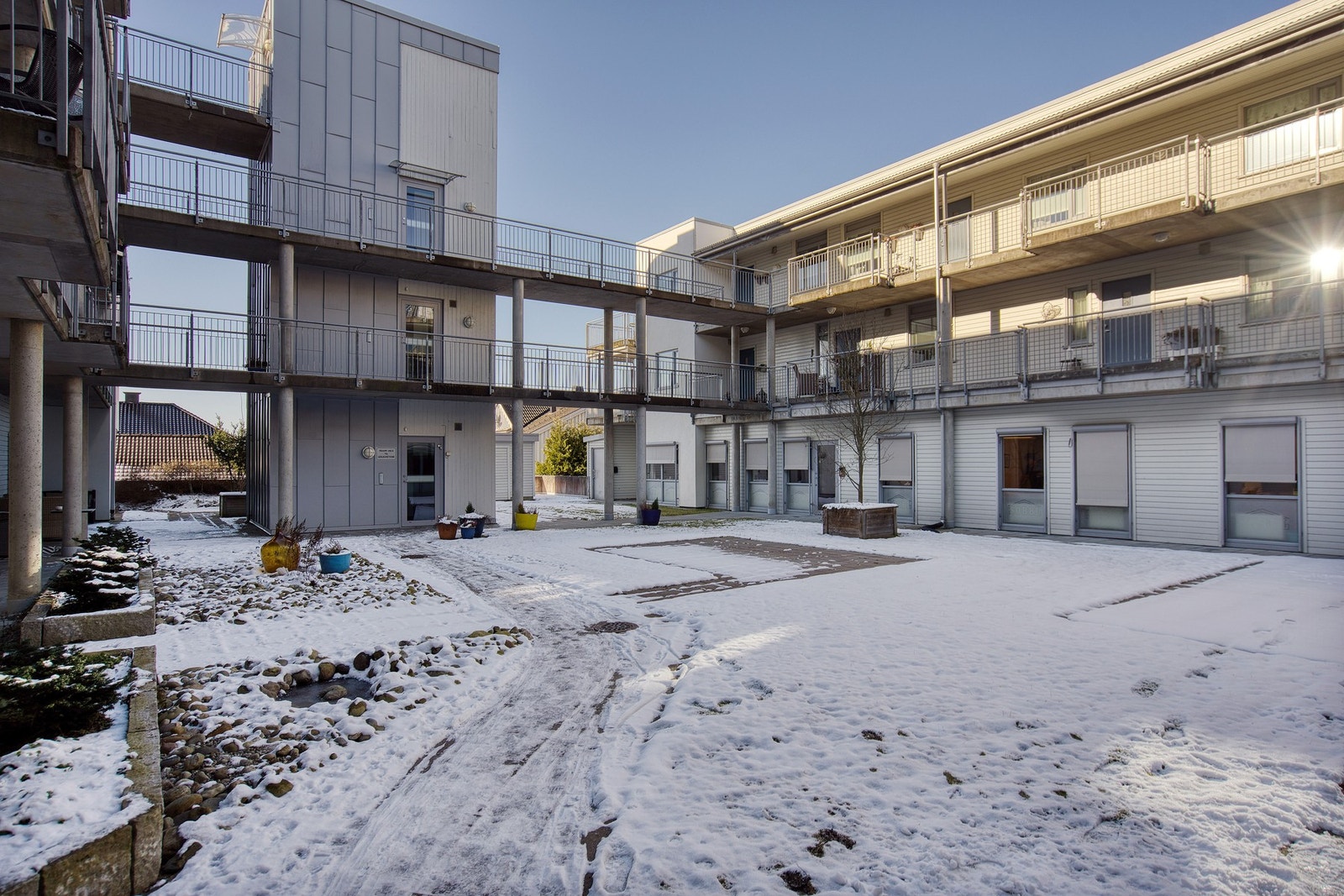 Velholdt borettslag med et lukket atrium i midten av bygningsmassen som er opparbeidet med gressplen, diverse beplantninger og gangareal belagt med heller. Her er det også oppført boder med mulighet for sykkelparkering. Galleribilde
