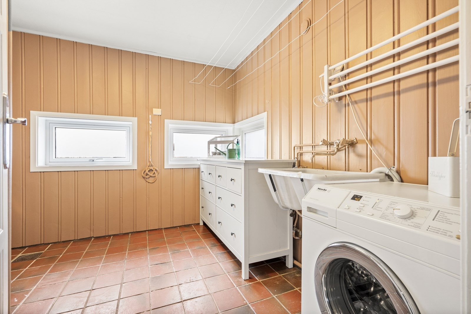 Romslig vaskerom med opplegg til vaskemaskin, utslagskum og dusj Galleribilde