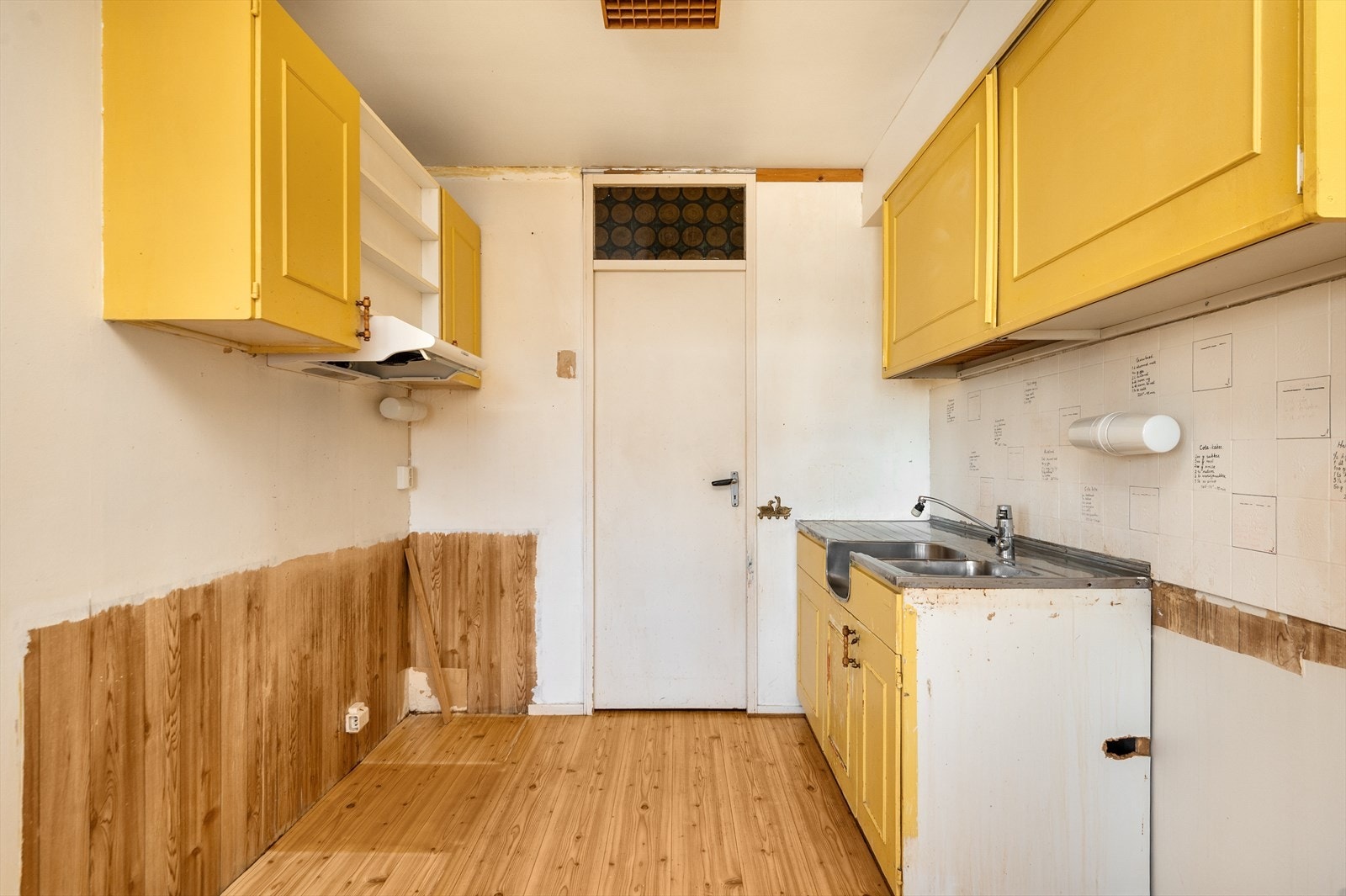 Det er belegg på gulv, malt glassfiberstrie og flis på vegg over benkeplate på vegger. Galleribilde