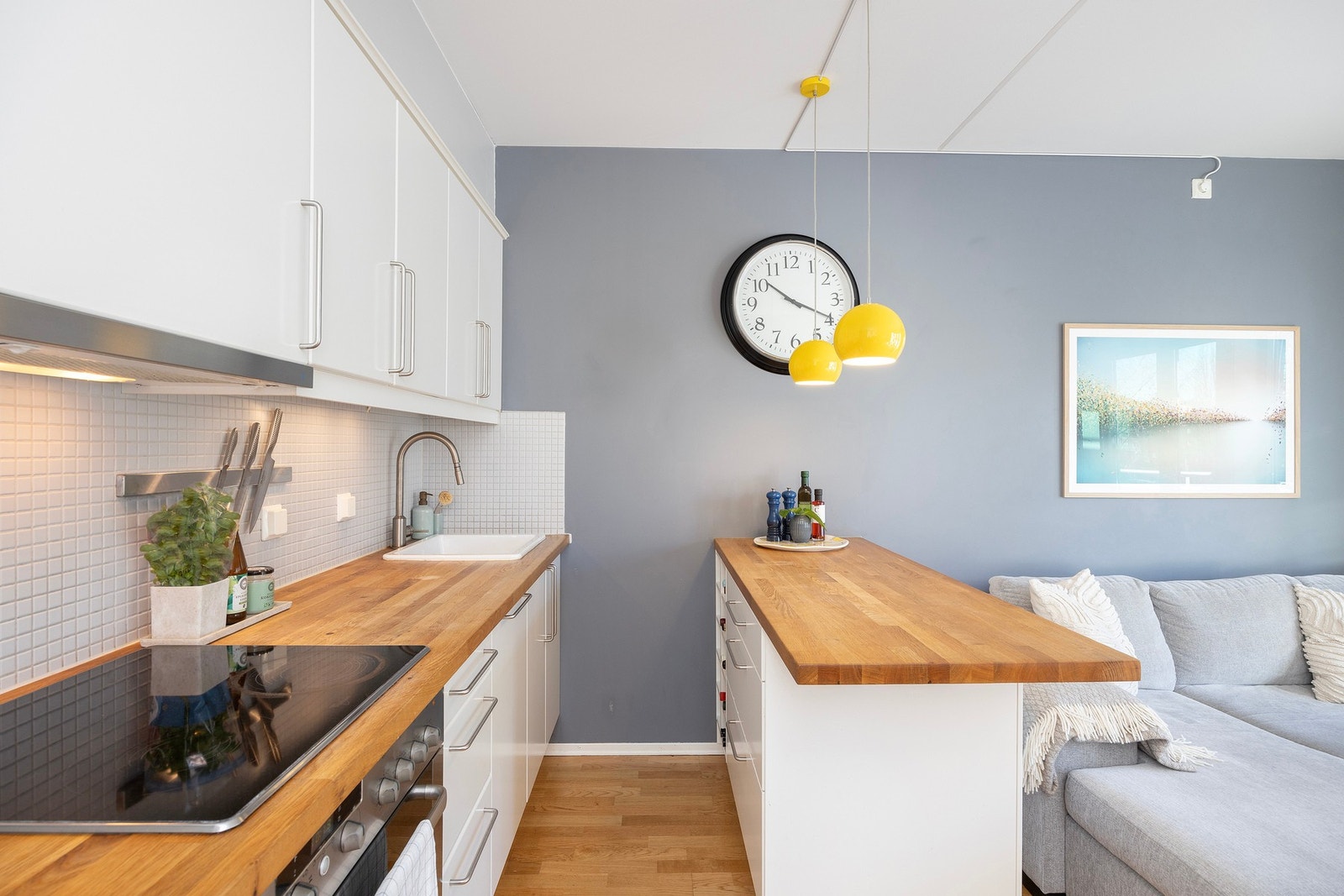 Kjøkkenet er innredet med over og underskap, komfyr, koketopp, nedfelt vask og vaskemaskin. Galleribilde