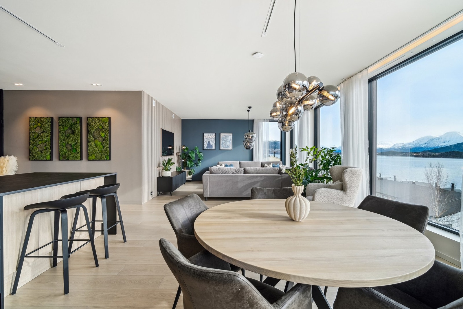 Stuen og kjøkkenet ligger i en åpen løsning med luftig takhøyde og panoramavinduer langs hele sydveggen og over på sidene. Galleribilde