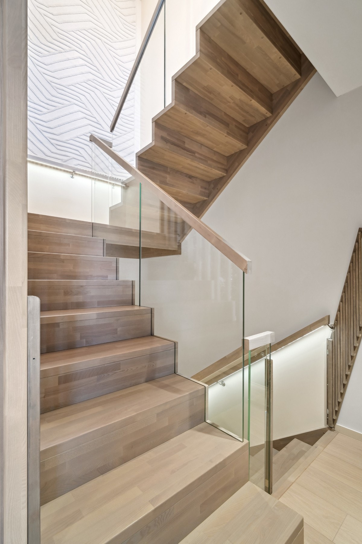 Trappen mellom etasjene har nærmest flytende trinn i ask og rekkverk i glass. Galleribilde