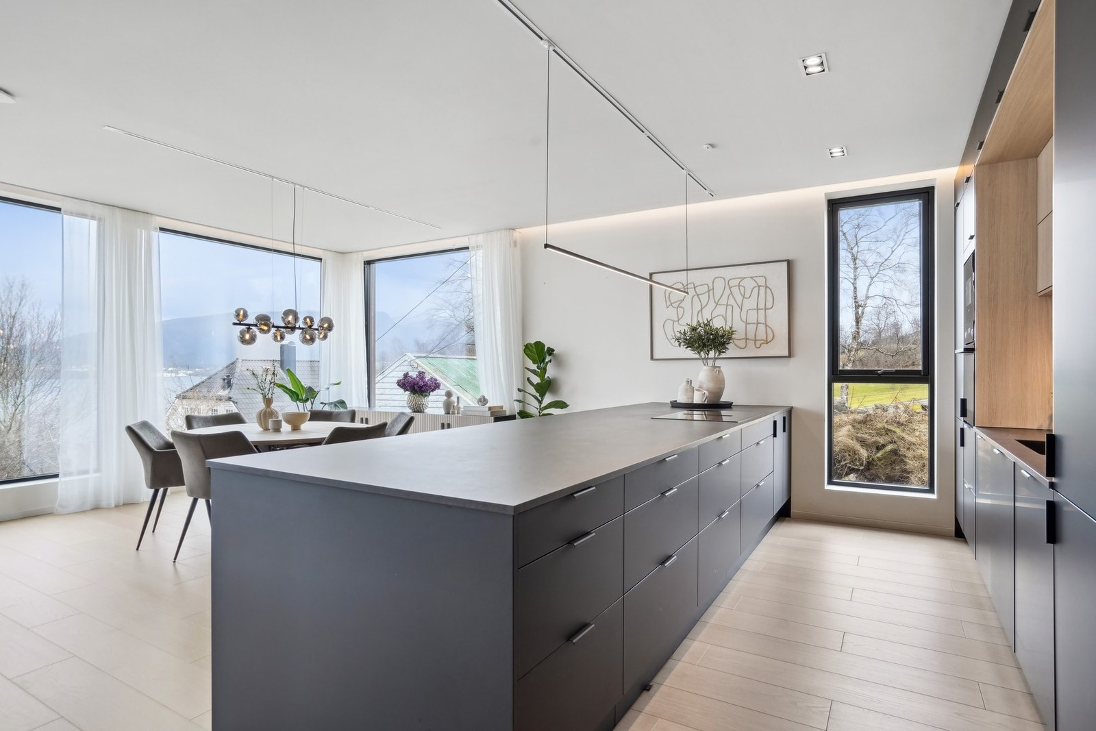 Lekkert med en takhøy innredning langs én vegg og en stor kjøkkenhalvøy ut mot stuen. Galleribilde