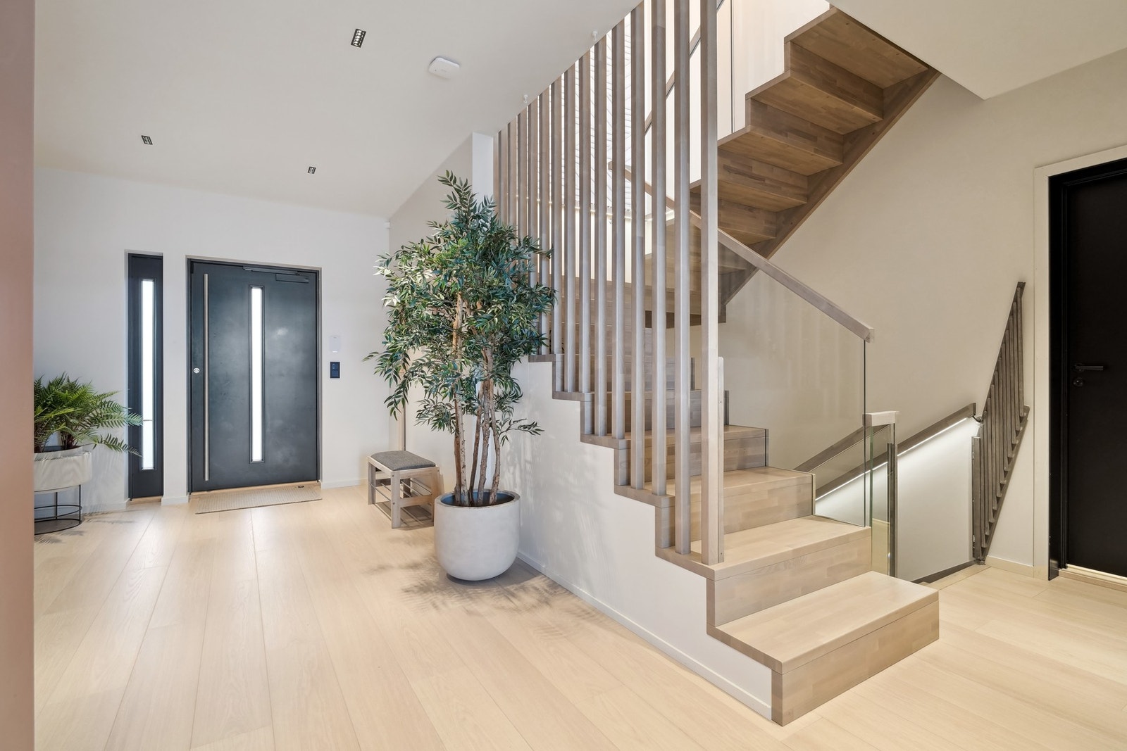 Velkommen inn! Stor hall i hovedetasjen med lekker trapp som har spilevegg og glassrekkverk. Galleribilde