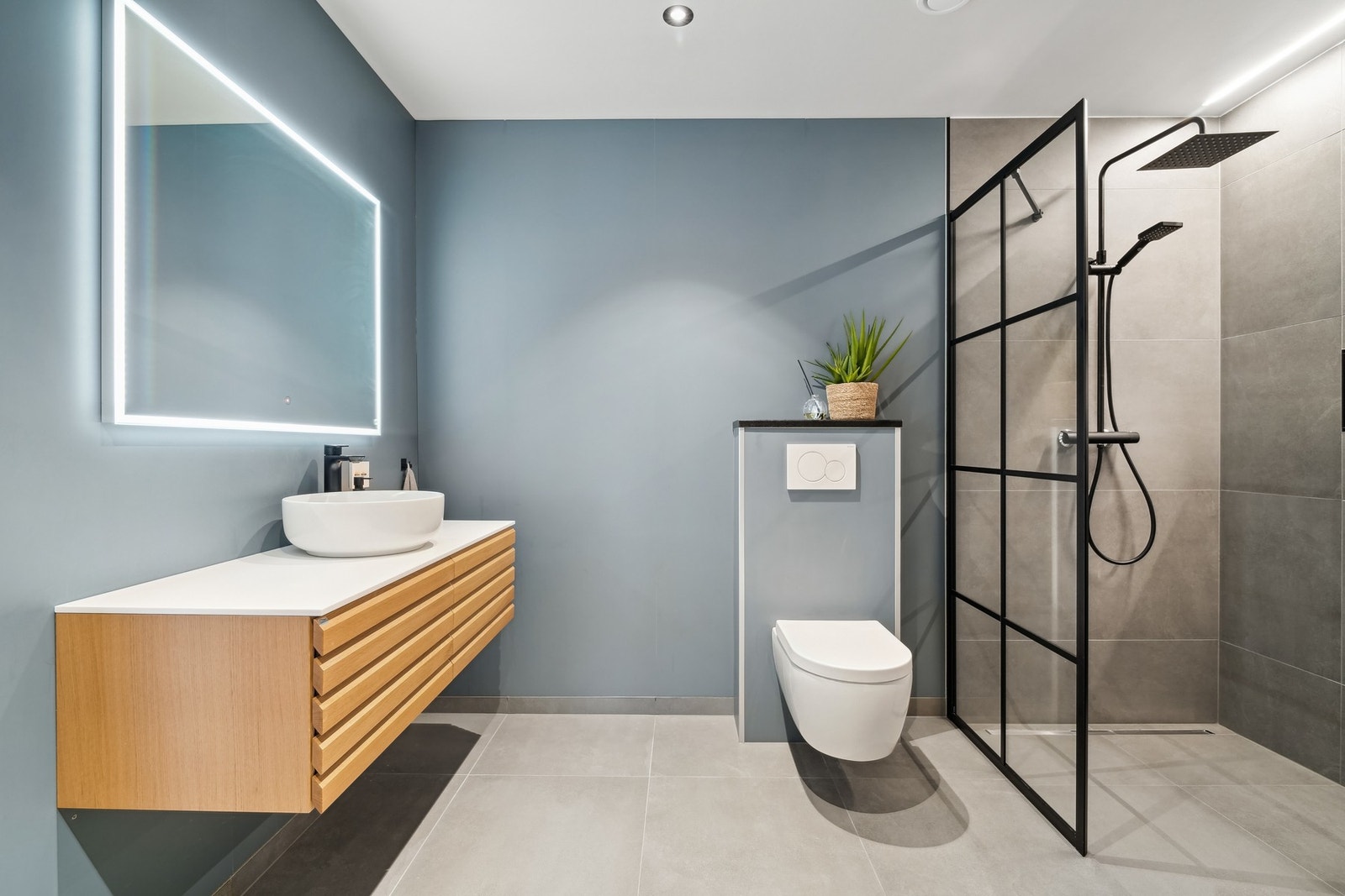 Badet i andre etasje har en stilren og pen innredning, veggmontert toalett og en dusjnisje med regnfallsdusj. Galleribilde