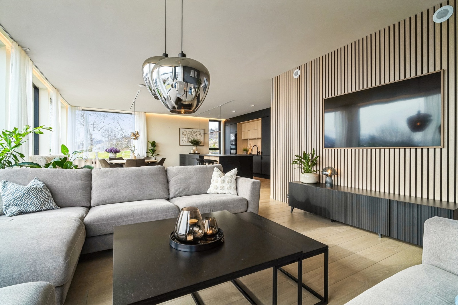 Stueveggene er lysmalte med blå fondvegg som henter opp farge fra omgivelsene, samt en tv-vegg kledd i lyse eikespiler. Galleribilde