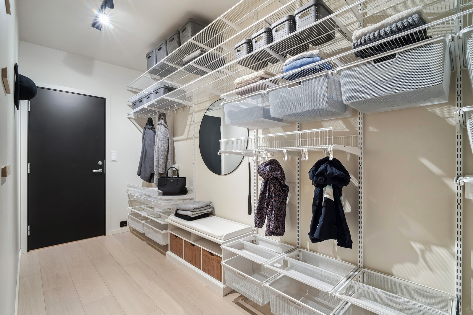 En sluse mellom garasjen og entreen er innredet med hyllesystem til yttertøy, sko og utstyr. Galleribilde