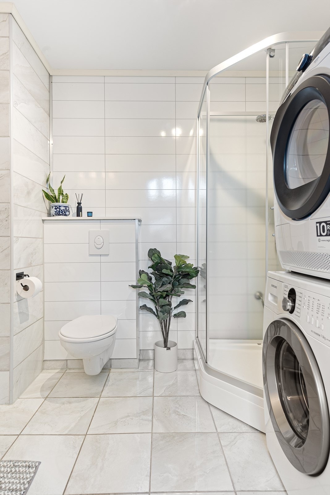 Badet er innredet med dusjkabinett, klosett og servant med innredning. Det er også opplegg for vaskemaskin. Galleribilde