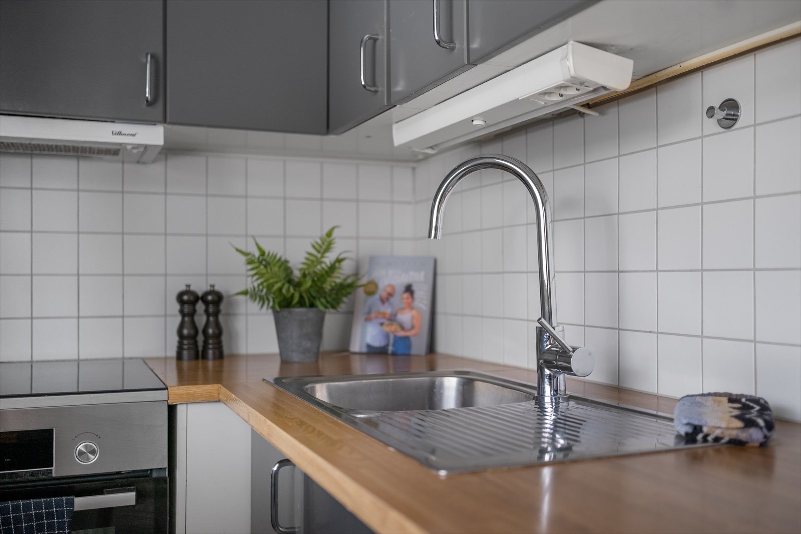 Kjøkkeninnredningen har skap med slette fronter og benkeplate av laminat med oppvaskkum av stål. Galleribilde