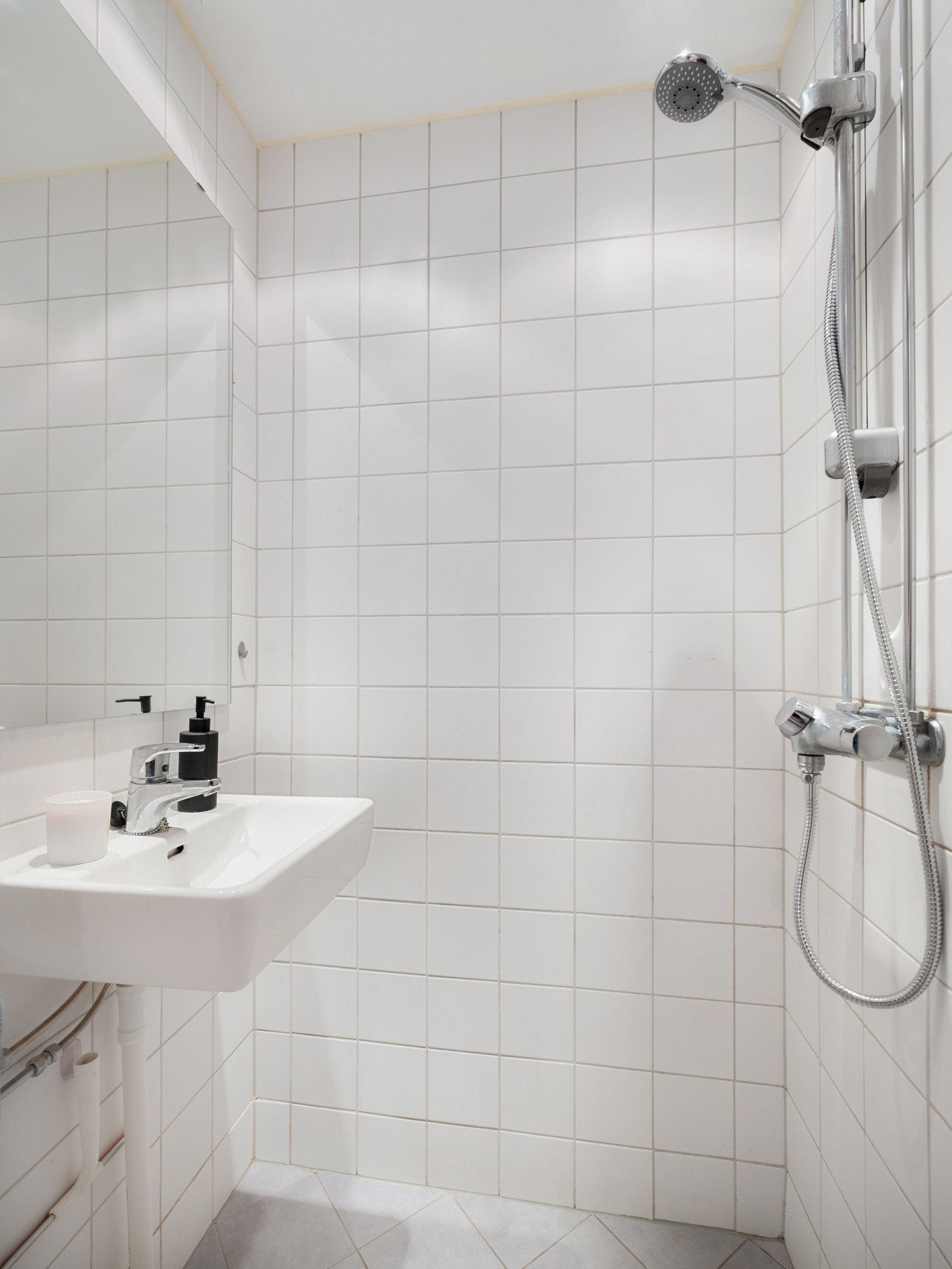 Badet inneholder porselensservant, veggmontert speil, veggmontert skap og vegghengt klosett. Galleribilde