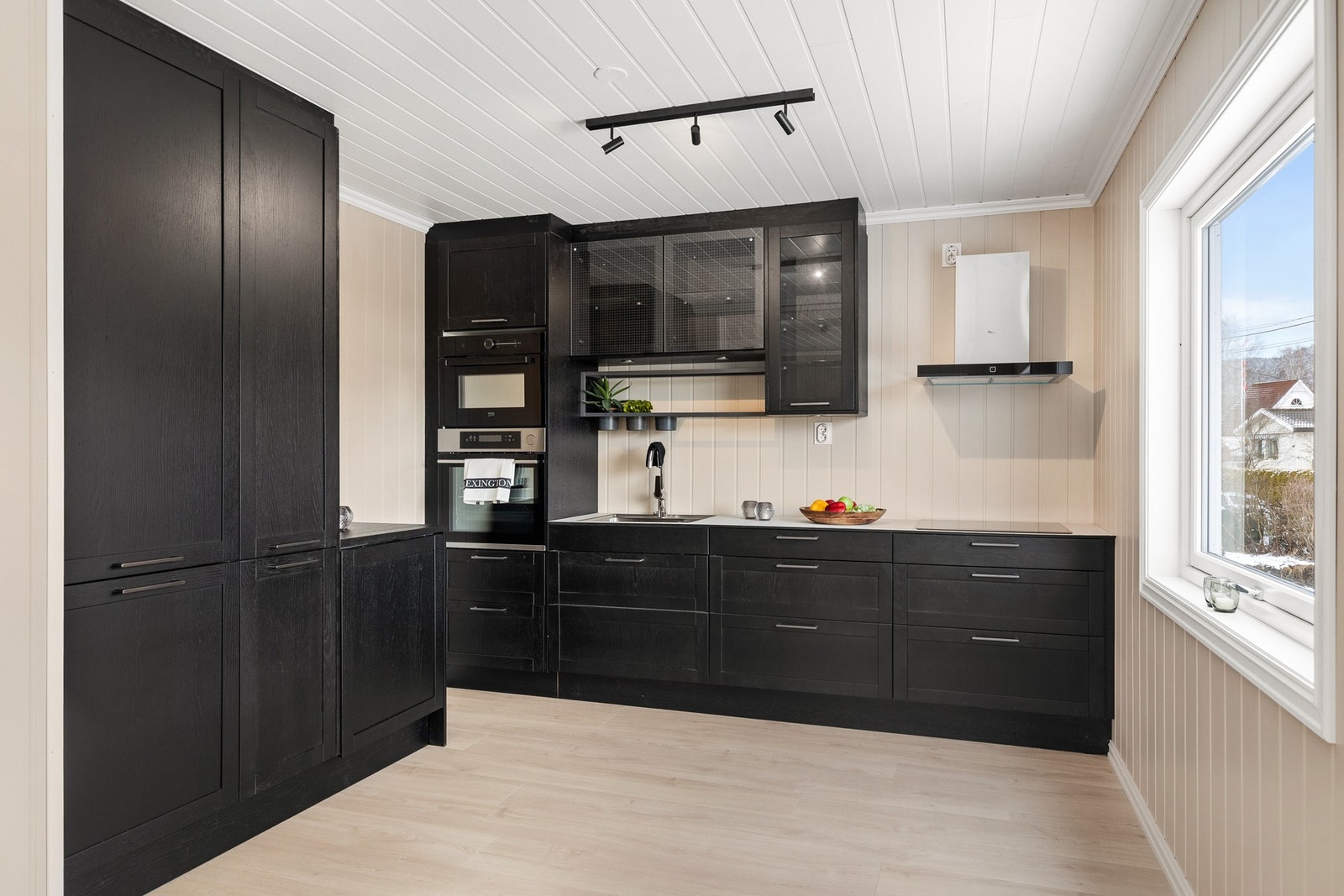 Kjøkkeninnredning med profilerte fronter og benkeplate av laminat med nedfelt oppvaskkum Galleribilde