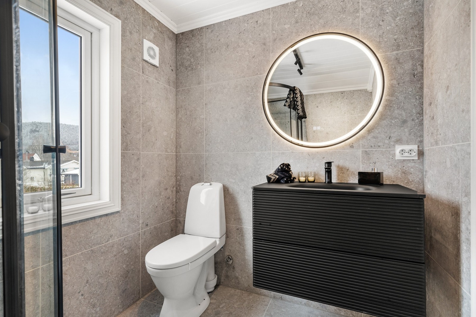 Videre er det montert en moderne servantinnredning og speil med integrert belysning Galleribilde