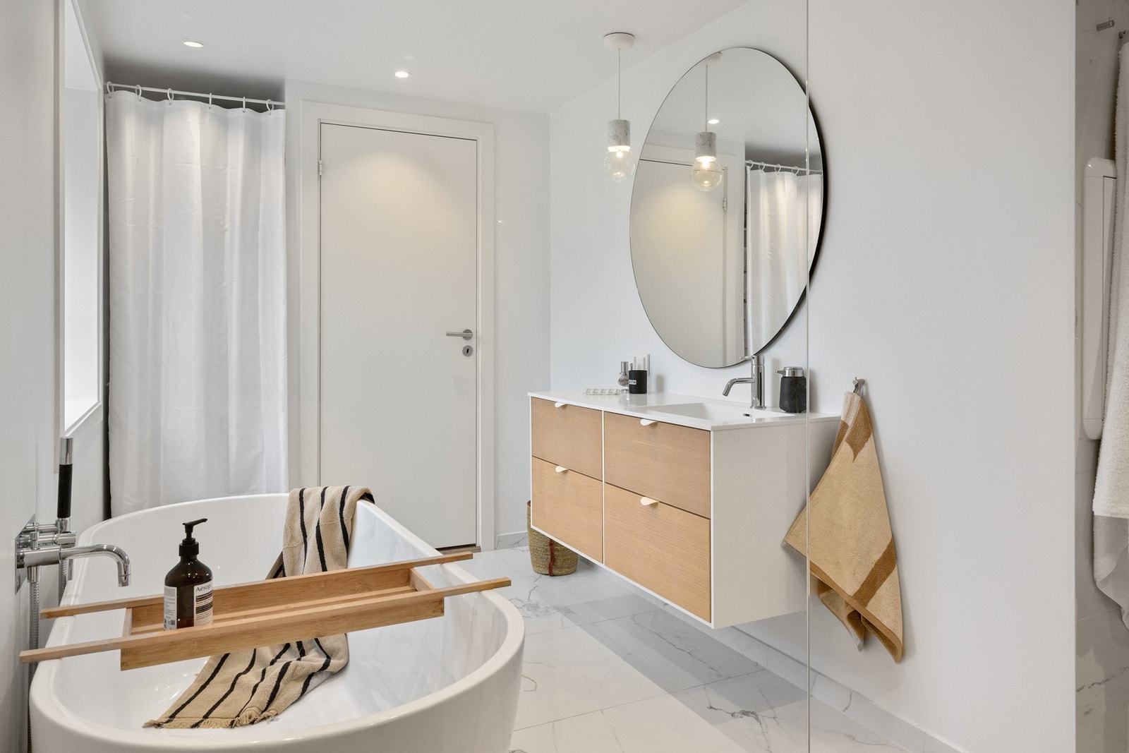 Servantskapet tilbyr god oppbevaringsplass med romslige skuffer. I tillegg er badet utstyrt med opplegg for vaskemaskin og tørketrommel i en praktisk søyleløsning. Galleribilde