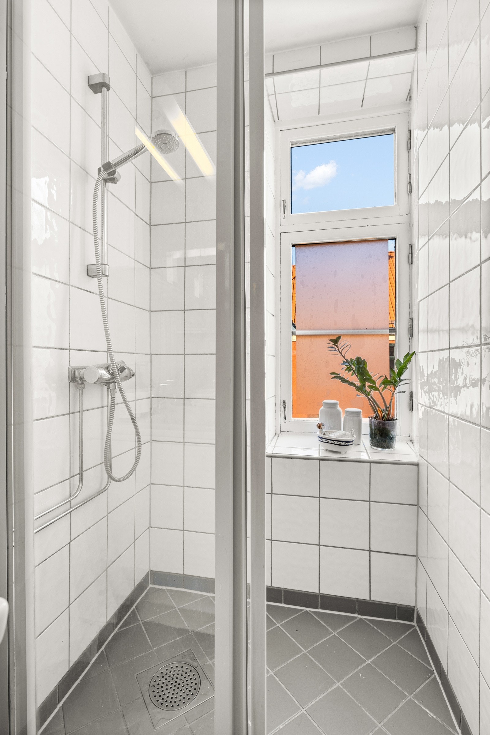 Stor dusjsone med skyvedører på skinne av glass og metall. Galleribilde