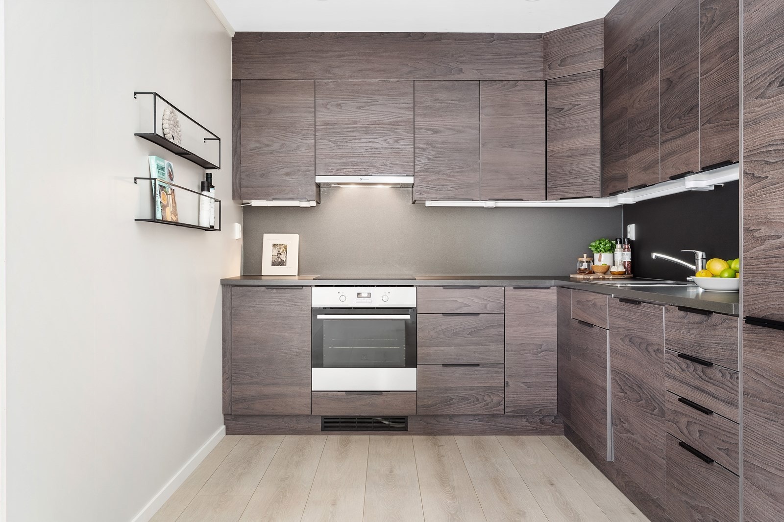 Kjøkkeninnredning fra Nygård Trevare som har mye skap og skuffepass. Integrerte hvitevarer fra Elektrolux: Komfyr, induksjonstopp, oppvaskmaskin og kjøl/fryseskap. Galleribilde