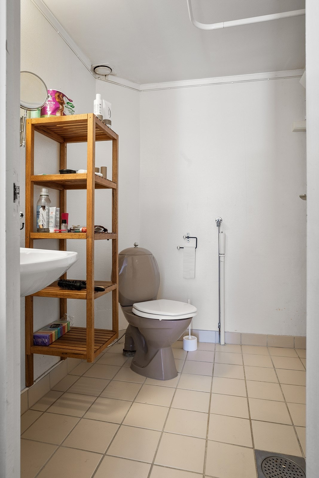 Badet er utstyrt med servant, åpen dusj og opplegg for vaskemaskin Galleribilde