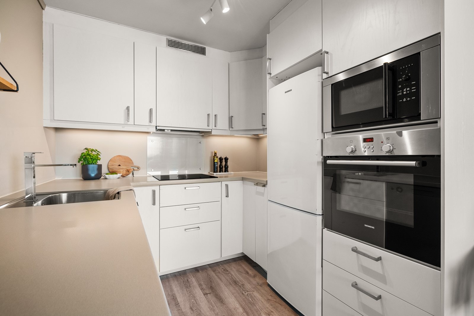 - Tidløs kjøkkeninnredning med slette fronter og benkeplate av laminat - Galleribilde