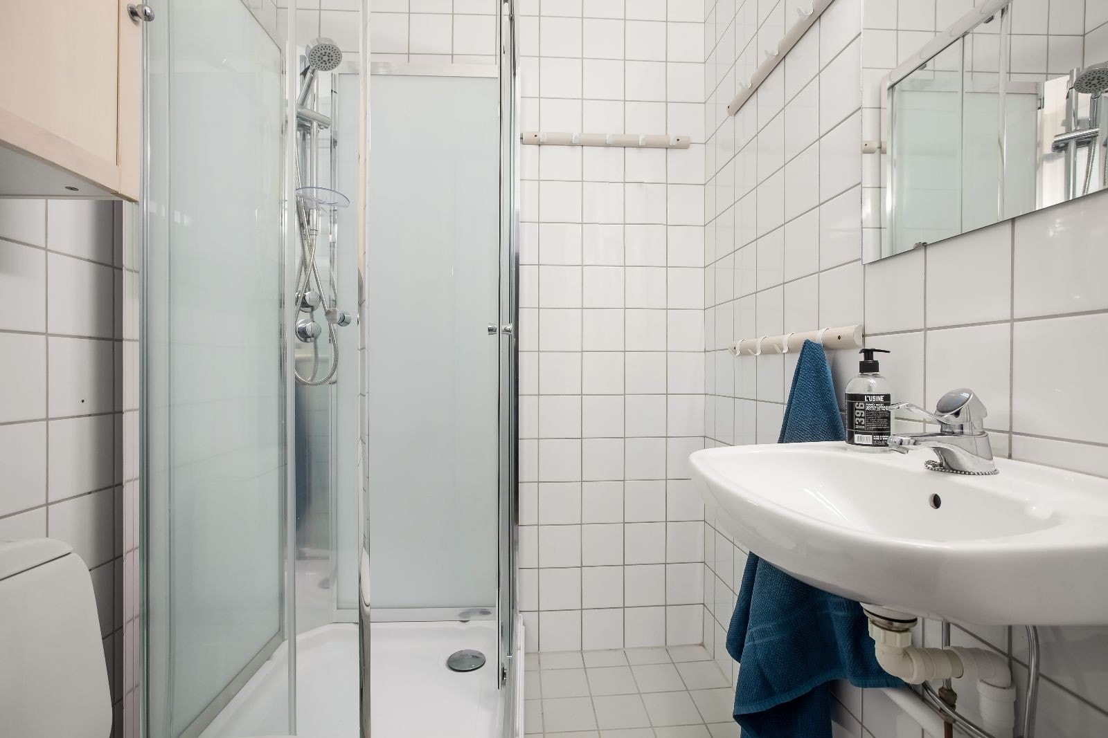 Flislagt bad med dusjkabinett og opplegg for vaskemaskin. Galleribilde