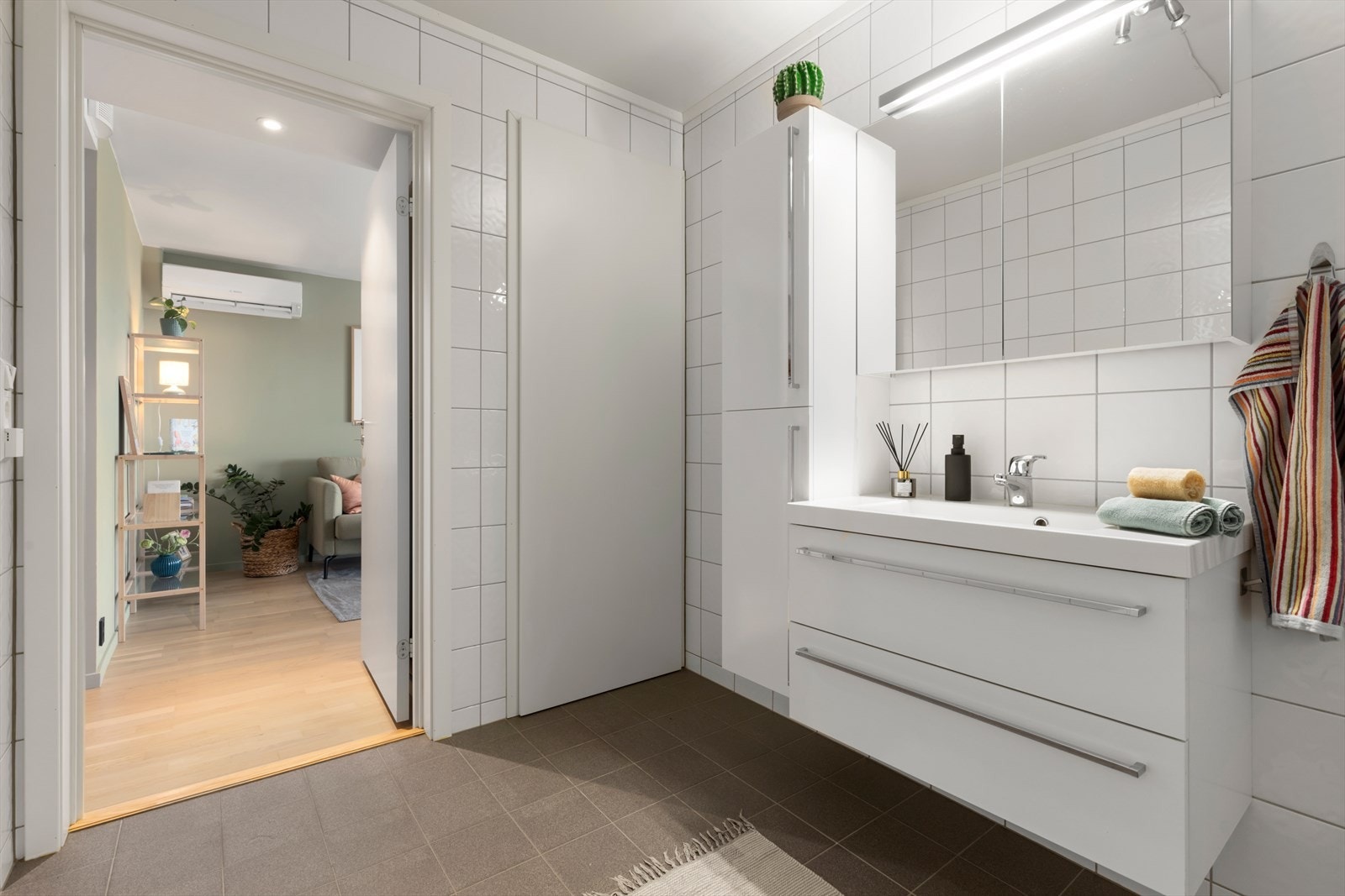 Badet har malt tak, flislagte vegger og gulv, samt baderomsinnredning med vegghengt WC og dusjvegger. Galleribilde