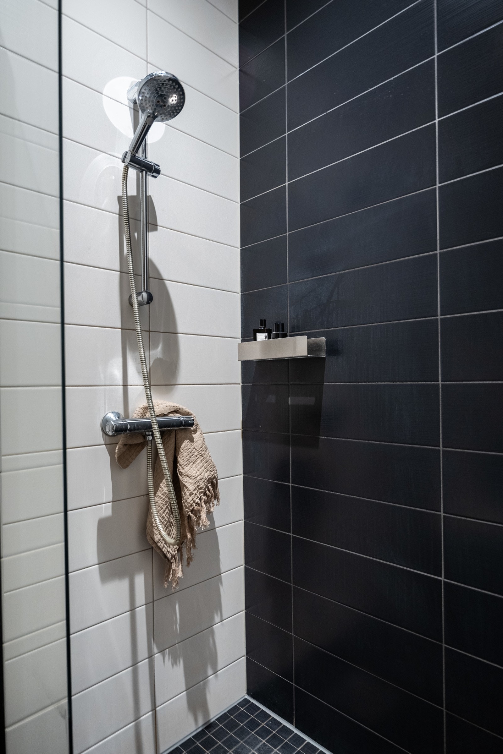 Stor dusjsone på gulv med dusjvegg av glass og metall. Galleribilde