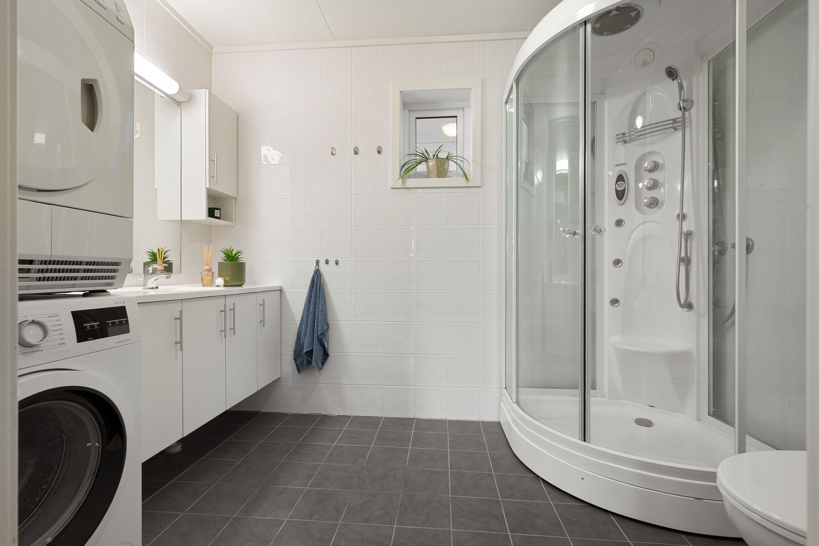 Lyst og fint bad med flislagte vegger og gulv med varmekabler under Galleribilde