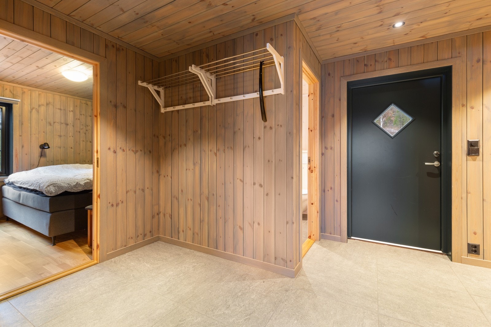 Inngangspartiet har flislagt gulv med varmekabler. Plass til oppheng av jakker og sko. Galleribilde