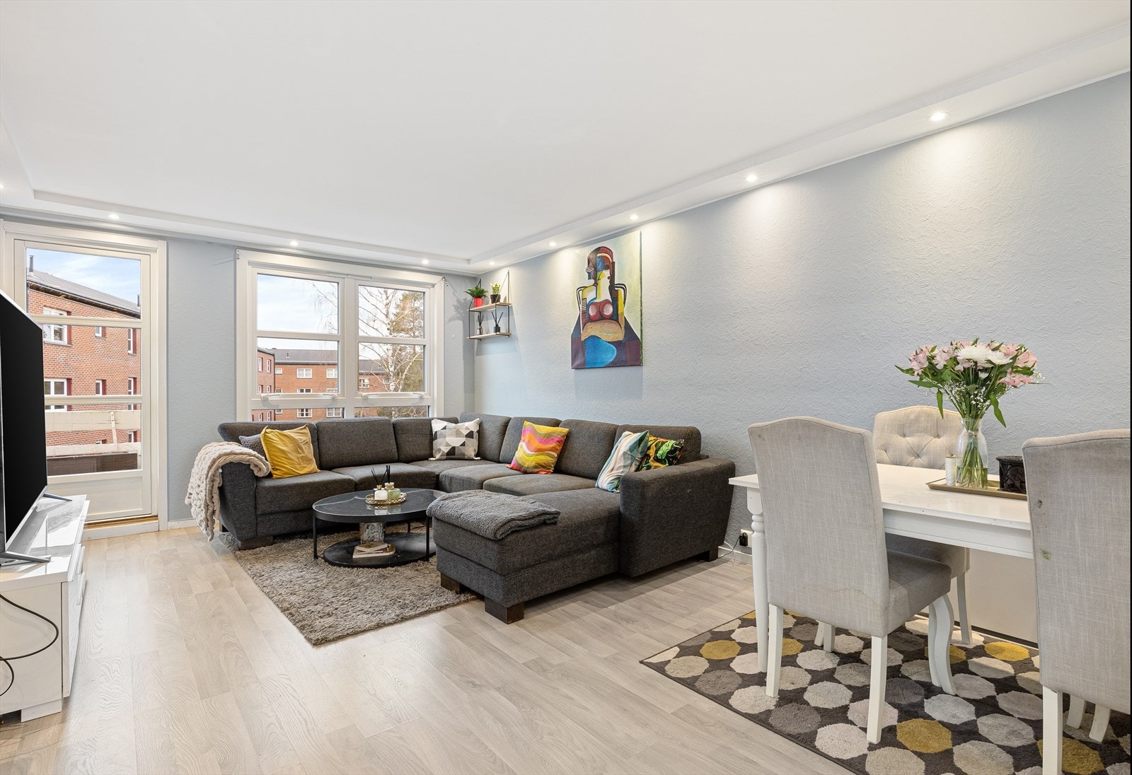 Pen og lys stue med downlights i himling og store vindusflater som gir godt med naturlig lysinnslipp. Galleribilde