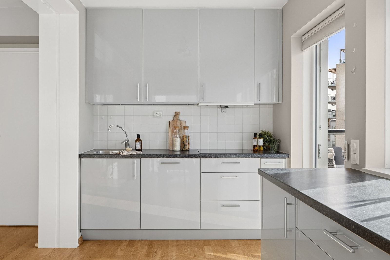 Innredningen er bestående av glatte fronter, benkeplater av laminat og nedfelt oppvaskkum med ett-greps armatur. Det er delvis fliser mellom kjøkkenbenk og overskap for enklere rengjøring. Galleribilde