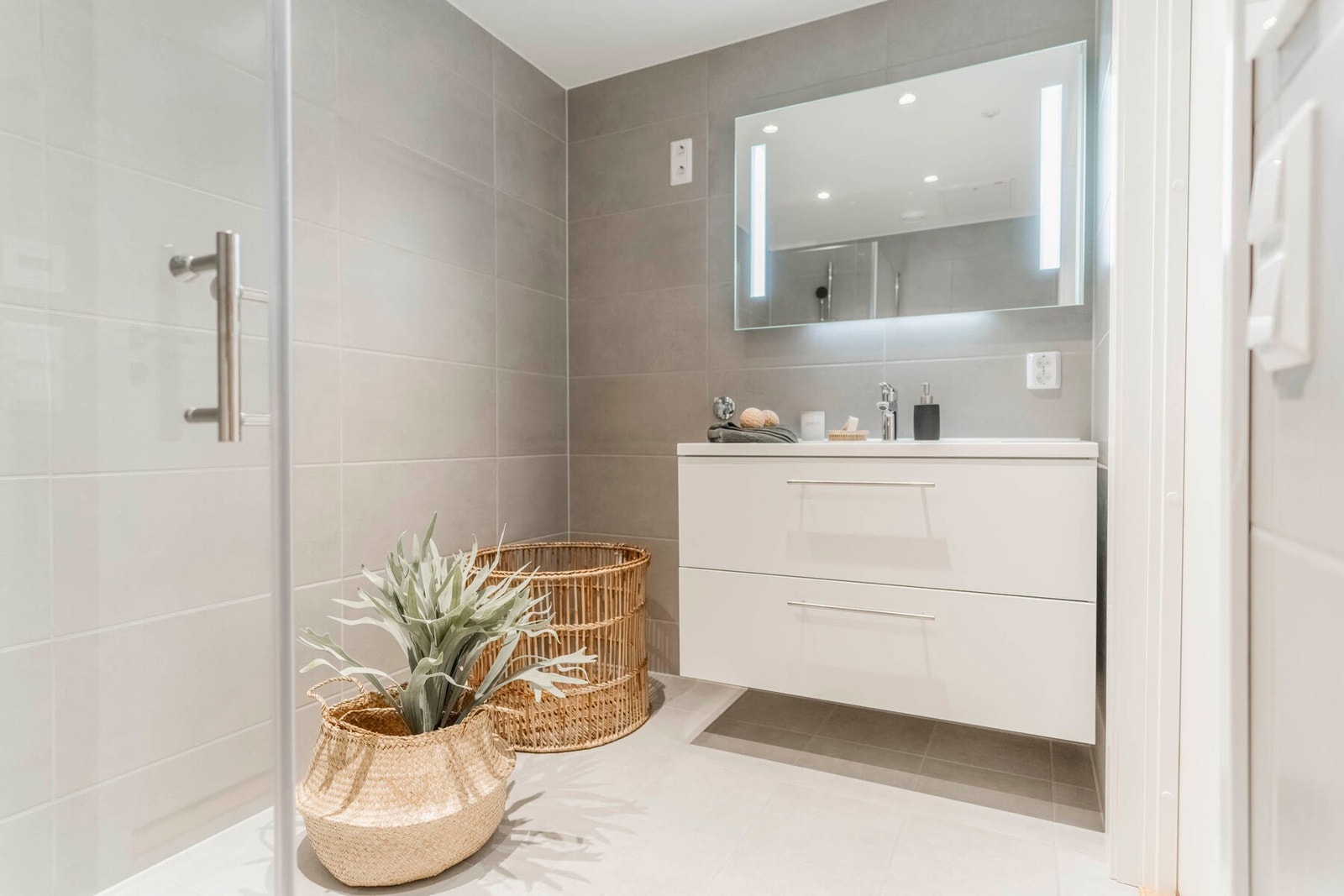 Delikat, flislagt bad med varmekabler i gulv og downlights i himling Galleribilde