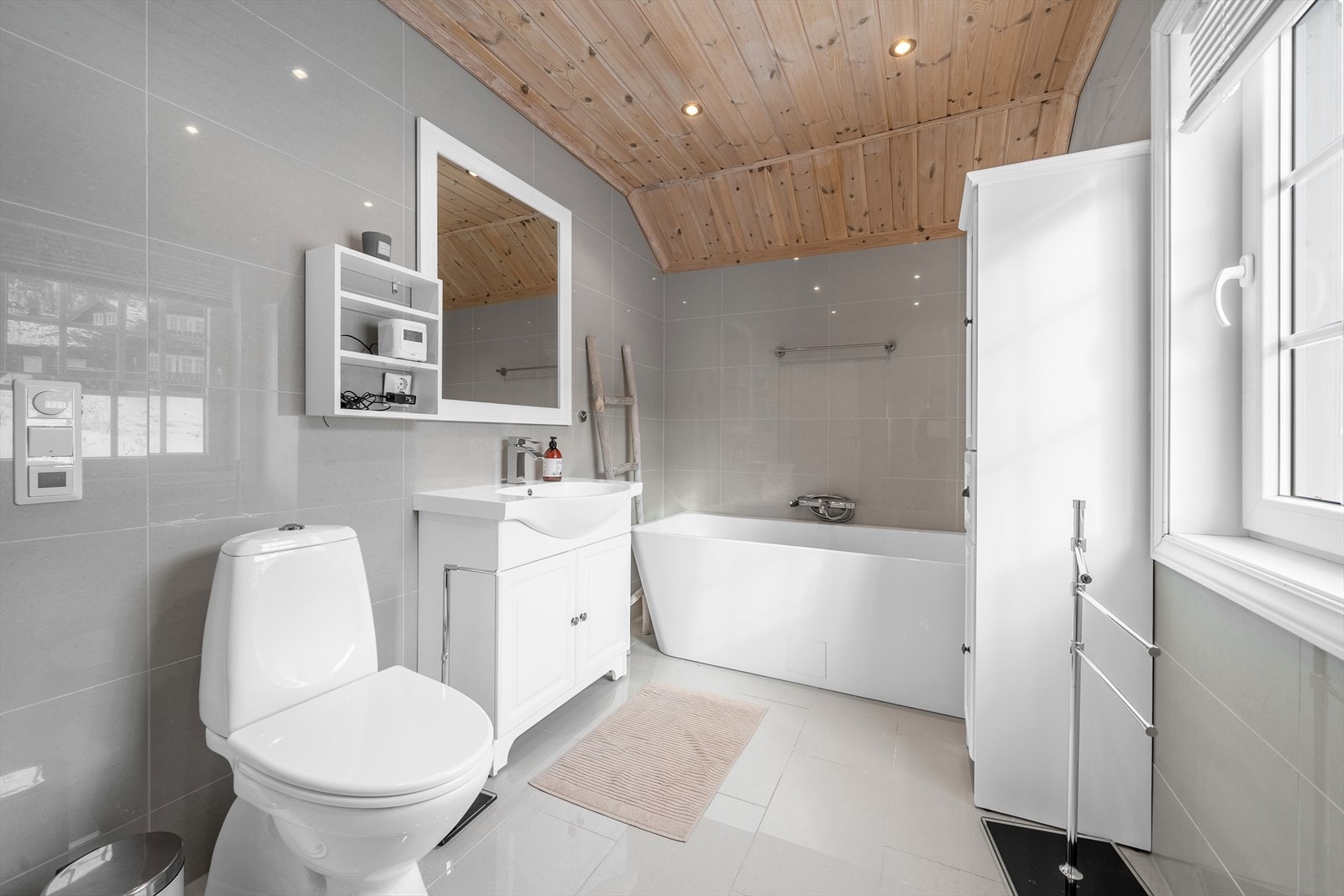 Baderomsinnredning med heldekkende servantplate, toalett og elektrisk avtrekk. Galleribilde