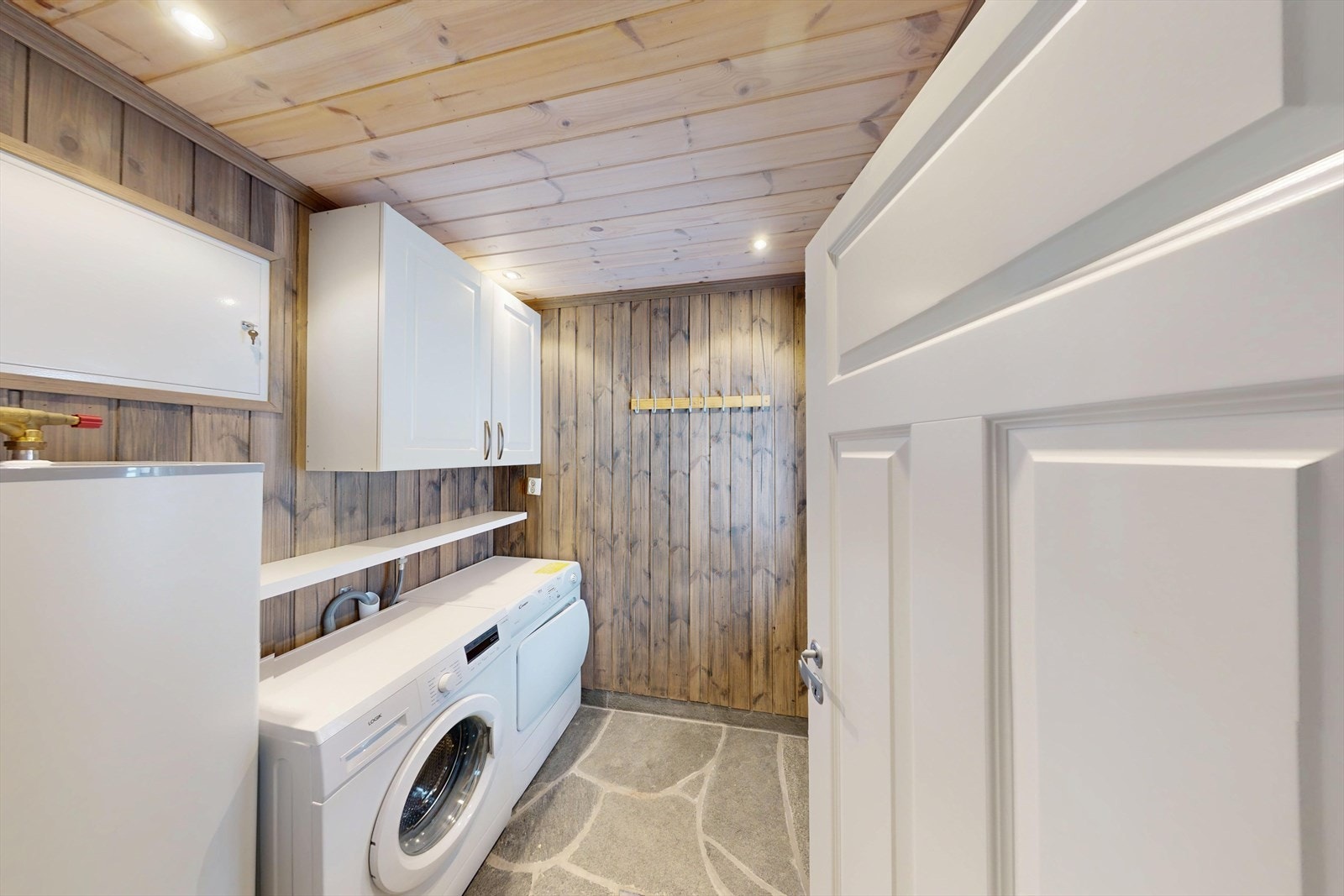 Vaskerommet i tilknytning til inngang er godt utnyttet. Med plass til både vaskemaskin og tørketrommel. Plassbesparende firkantet varmtvannsbereder, vannfordelingsskap og sikringsskap er plassert på vaskerom. Galleribilde