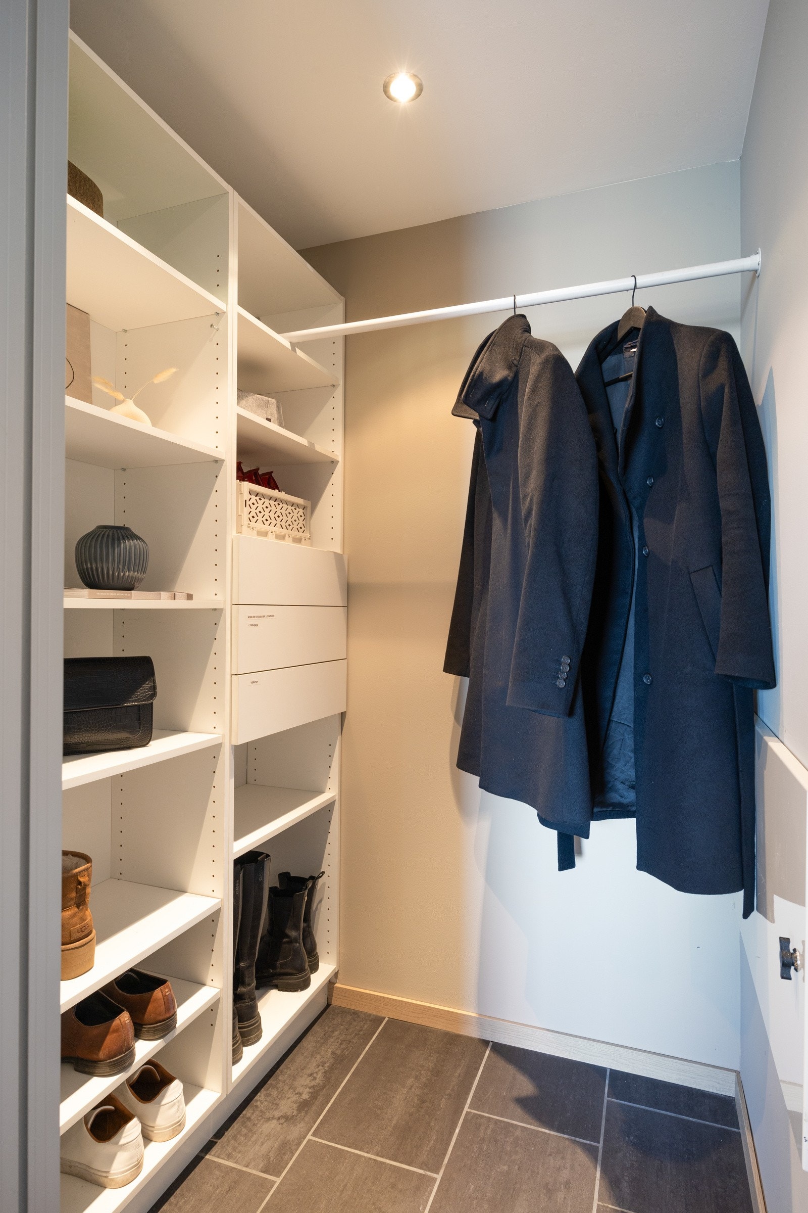 Pent kledd med flislagt gulvflate og downlights, og praktisk innredet med oppbevaringsplass og oppheng. Galleribilde