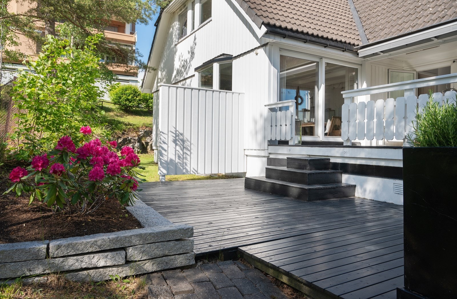 Det er trapp ned til hagen fra terrassen. Hagen omkranser huset. Galleribilde