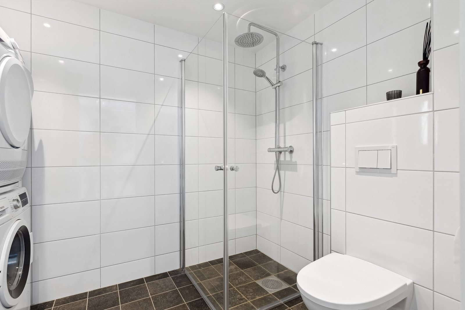 Badet har servantinnredning, dusjhjørne og veggmontert toalett. Galleribilde