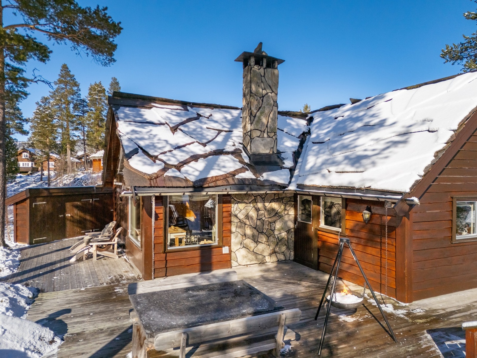 Taket er tekket med store bruddskiferplater, og pipa i naturstein fra området. Galleribilde