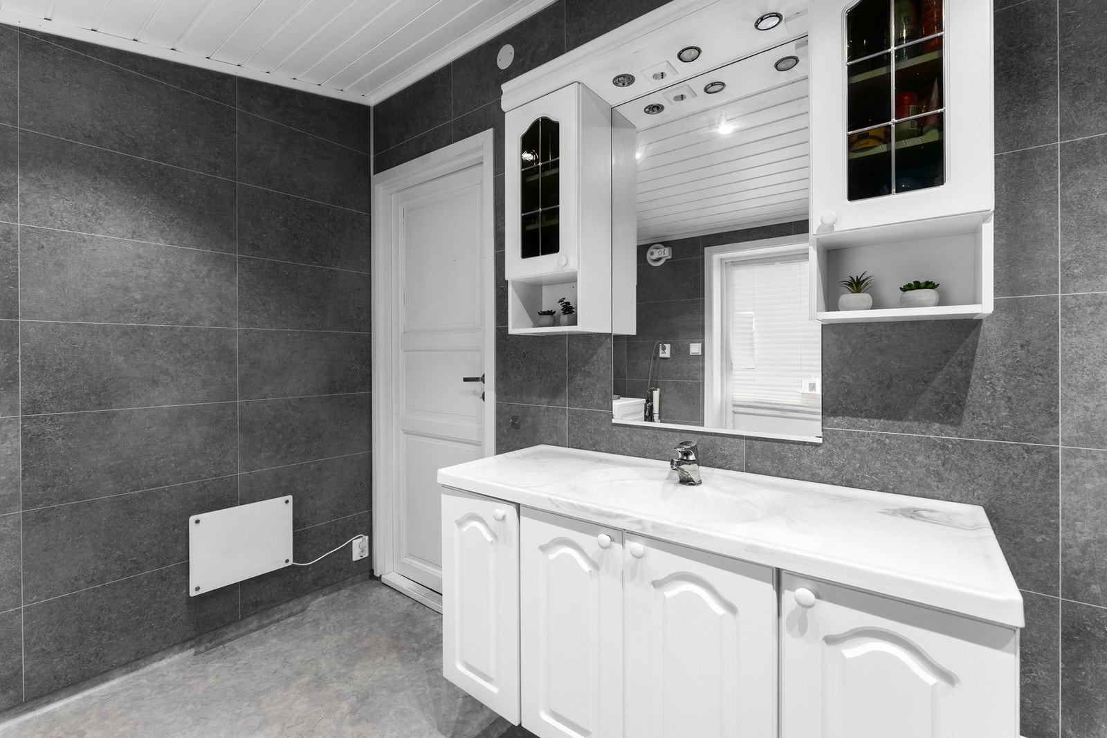 Badet er innredet med en praktisk innredning, dusjkabinett, toalett og opplegg for vaskemaskin. Galleribilde