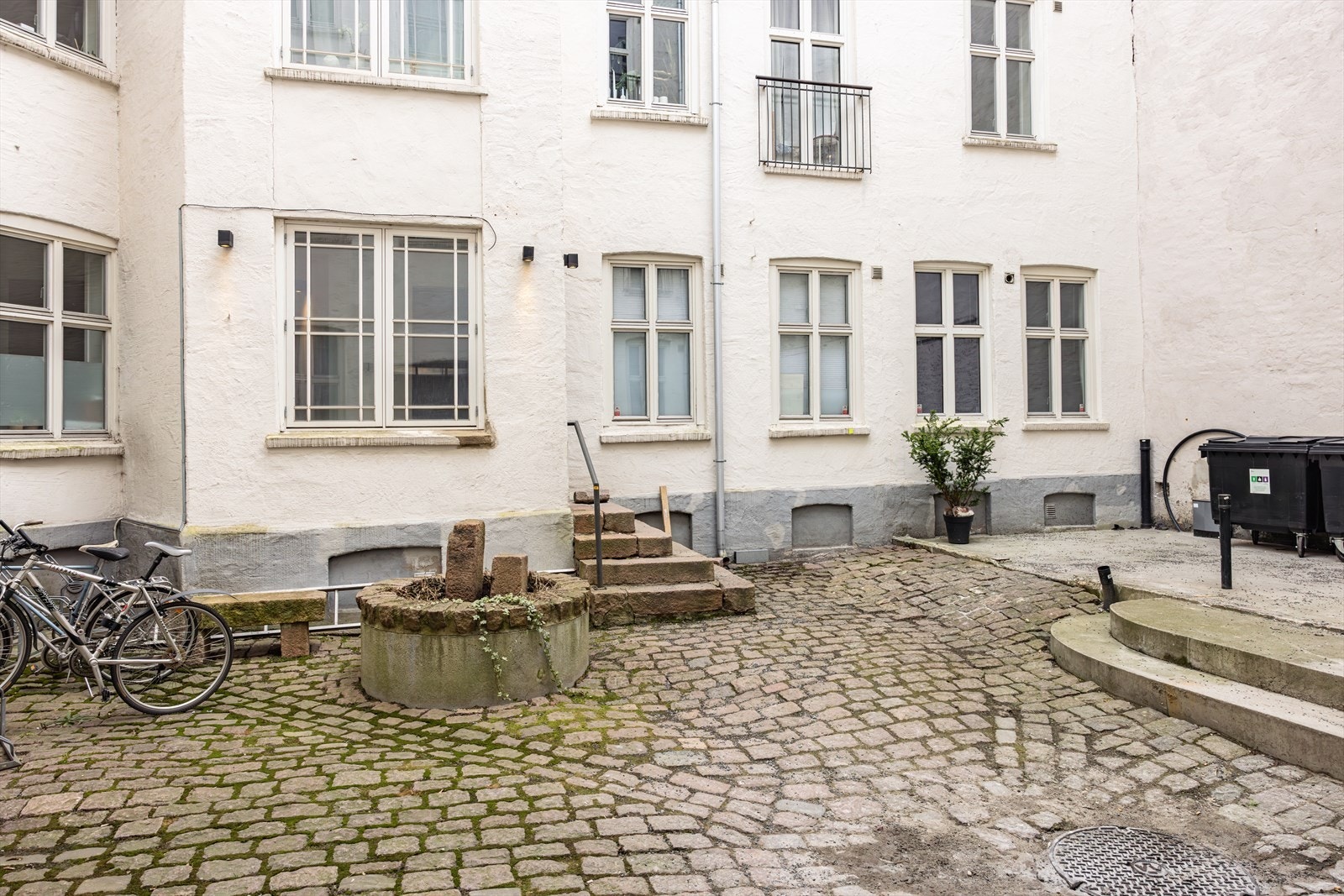 Bakgården er brosteinsbelagt og har en koselig atmosfære med sykkelparkering, beplantning og en felles oppholdsplass hvor man kan nyte rolige omgivelser midt i byen. Galleribilde