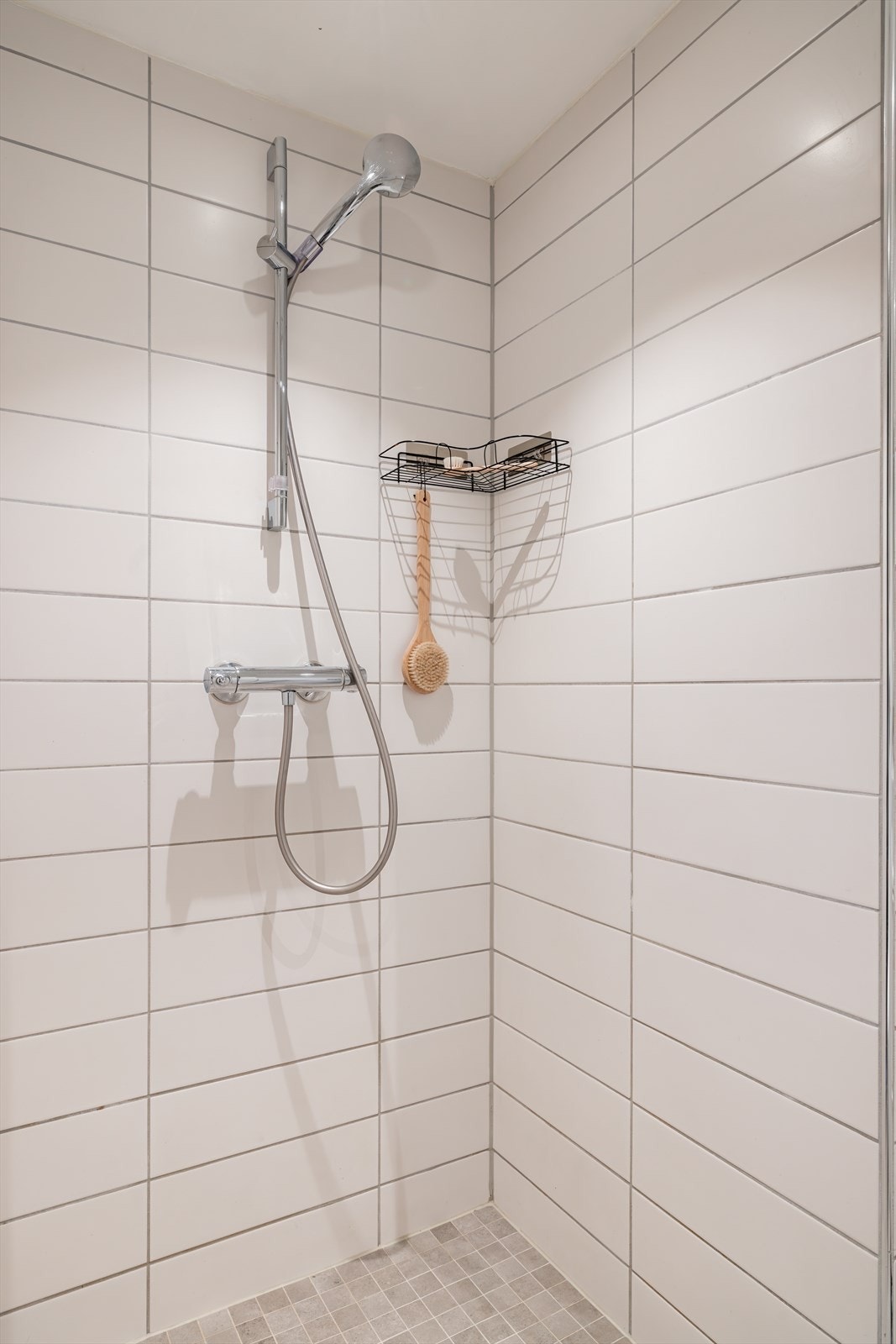 Badet er innredet med servantskap med servant, innmurt speil, vegghengt klosett med innebygd sisterne og dusjsone med dusjforheng. Galleribilde