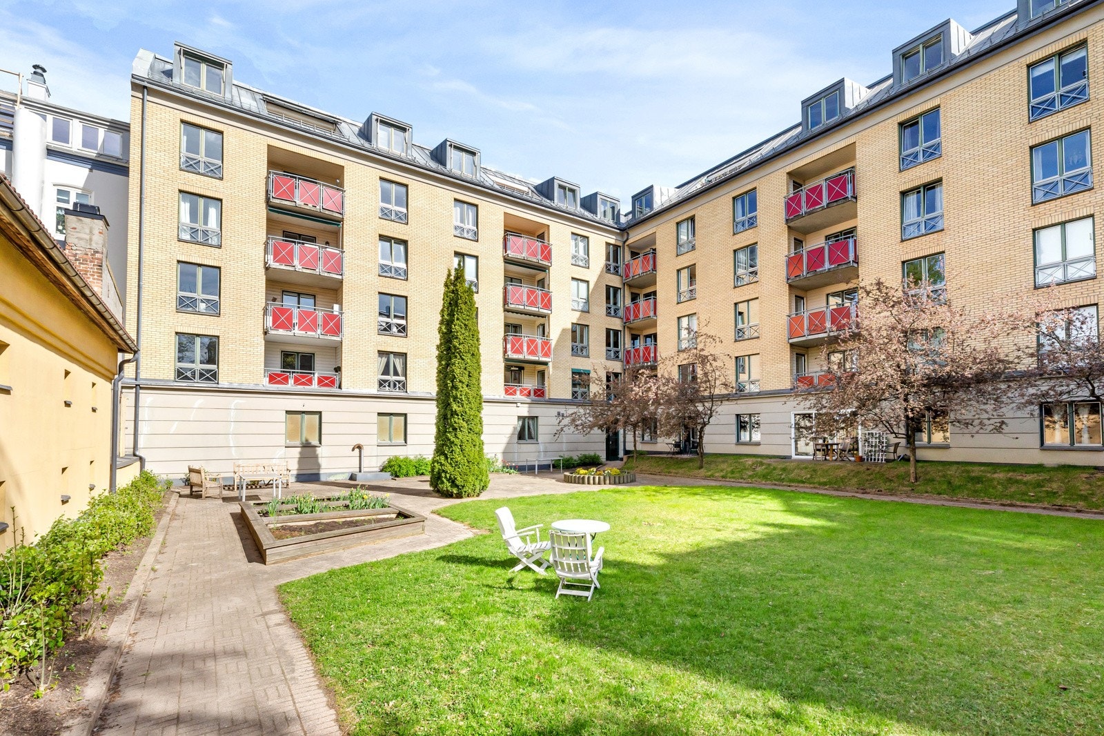 Pent opparbeidet felles tomt med stor plen, prydbusker og sittegrupper. Galleribilde