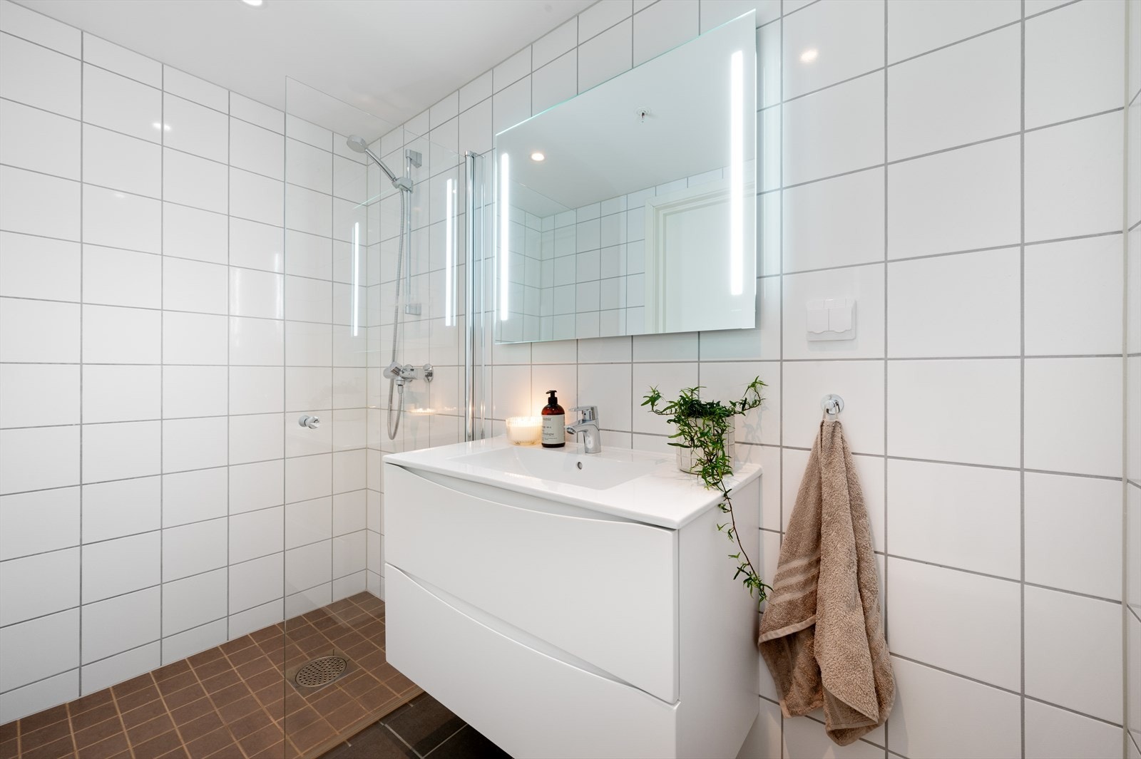 - Badet er innredet med servantmøbel, speil med integrert belysning, vegghengt toalett og dusjnisje med glassdør - Galleribilde