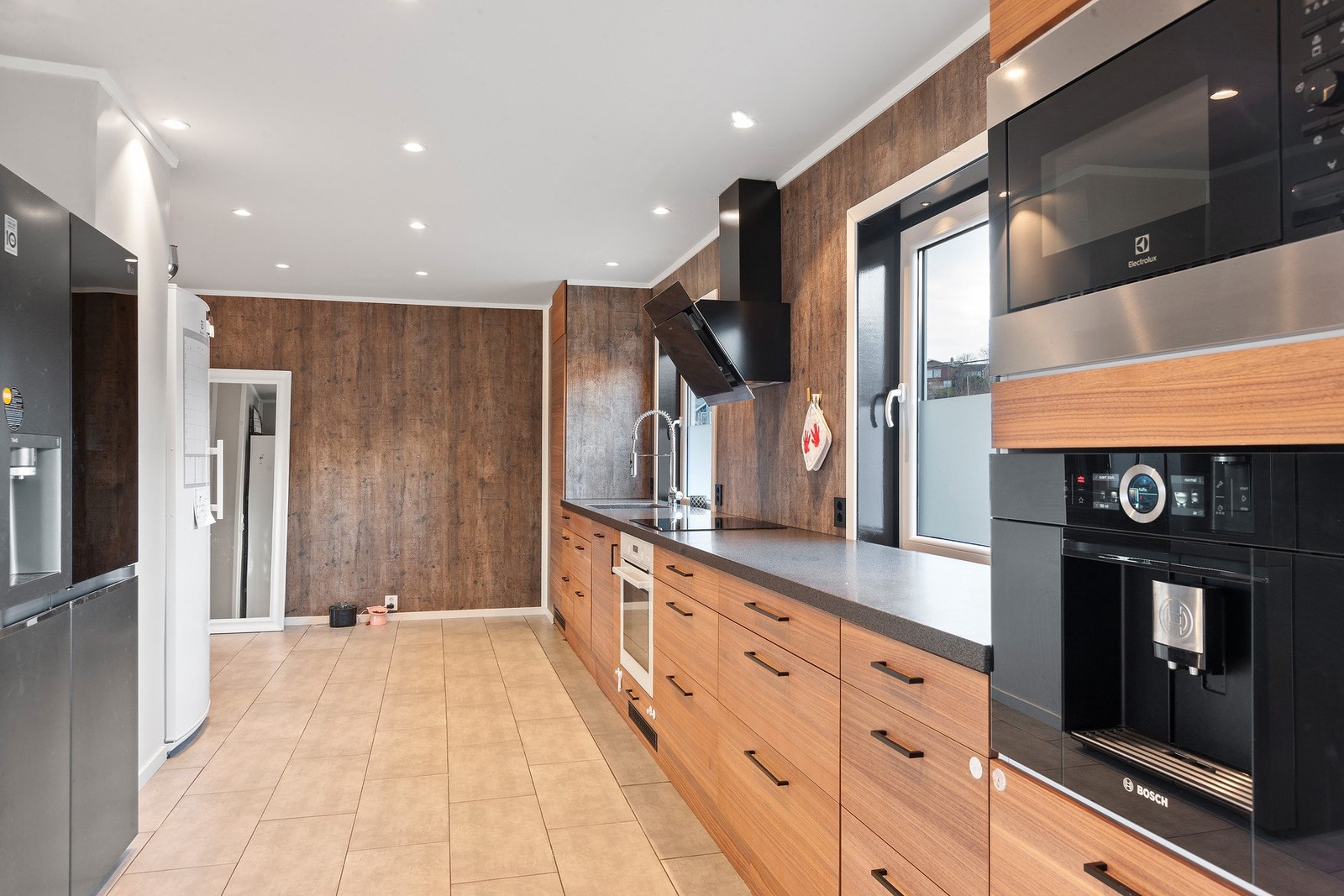 Kjøkken med oppvaskmaskin, komfyr, induksjonstopp, kaffemaskin og micro. Galleribilde