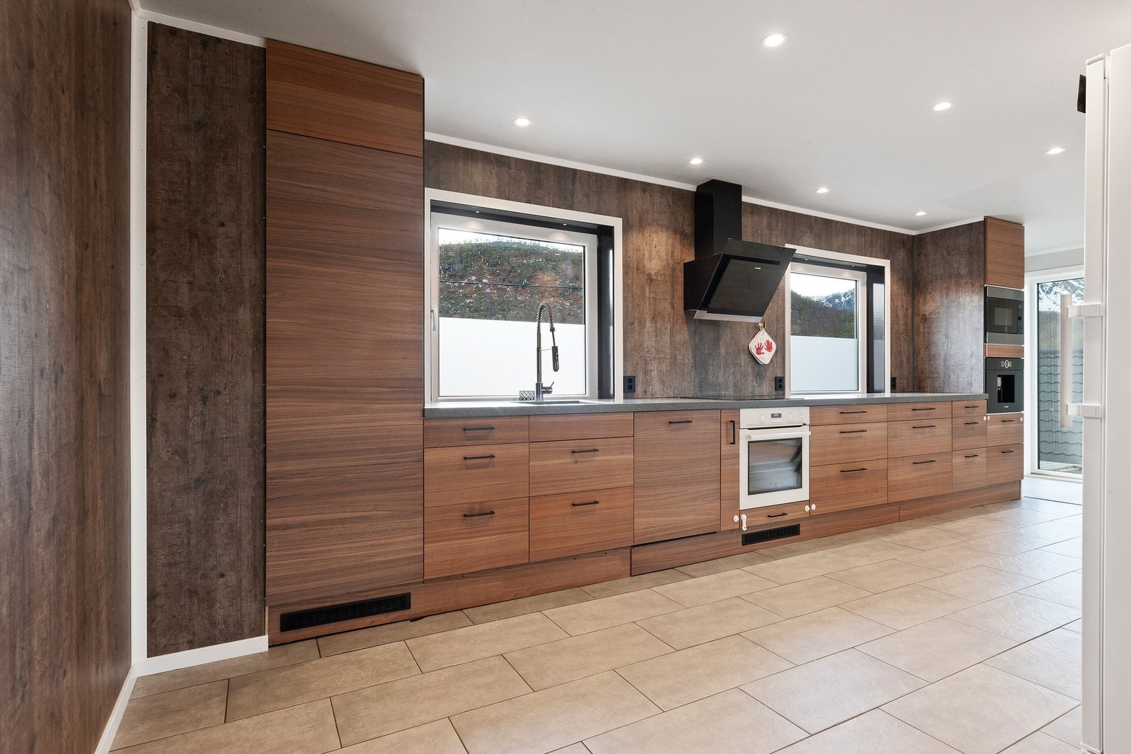 Kjøkkeninnredning med glatte fronter. Benkeplaten er av kompositt. Galleribilde