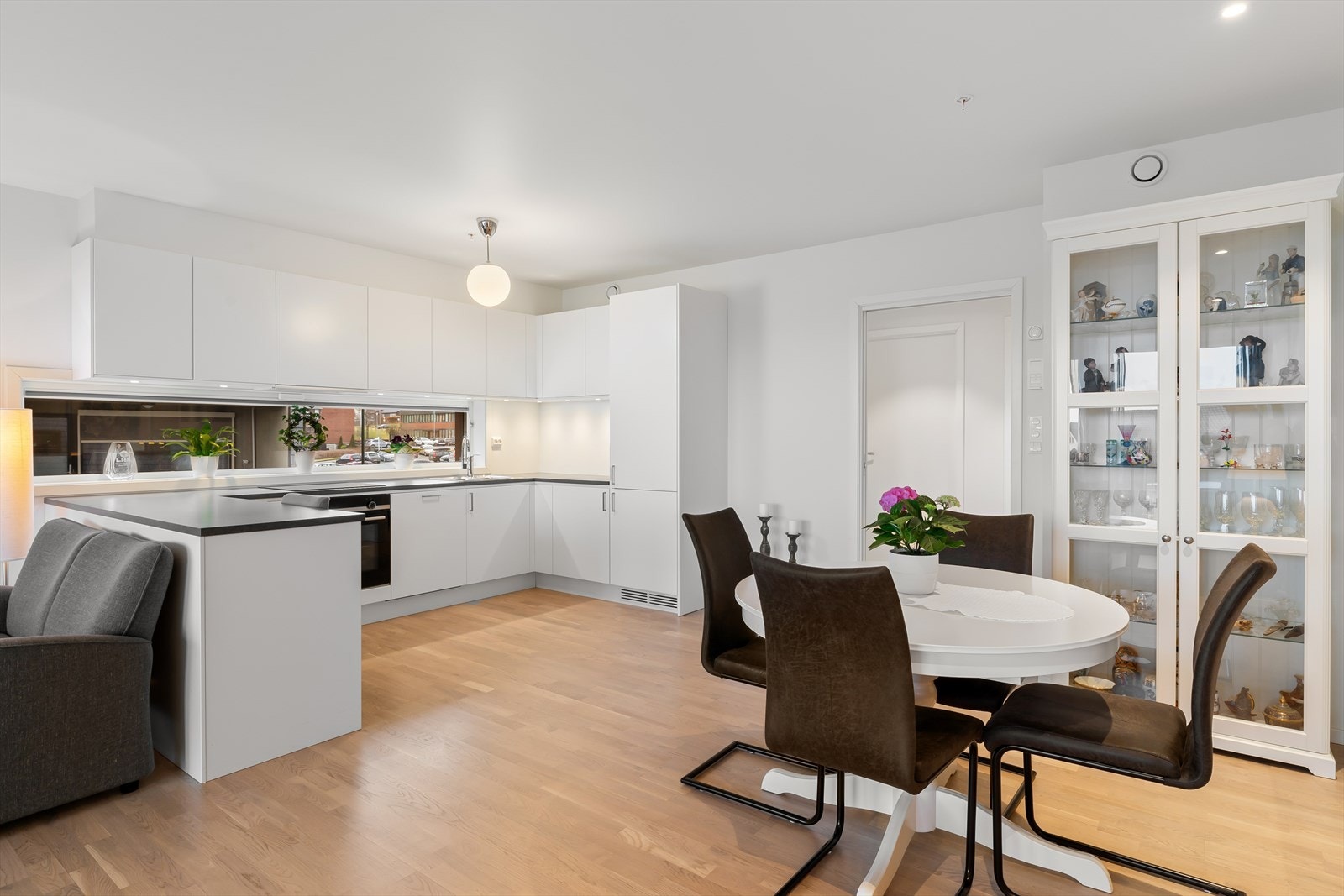 Kjøkkenet er utstyrt med hvite, slette fronter og integrerte hvitevarer, noe som gir et stilrent og moderne uttrykk. Galleribilde