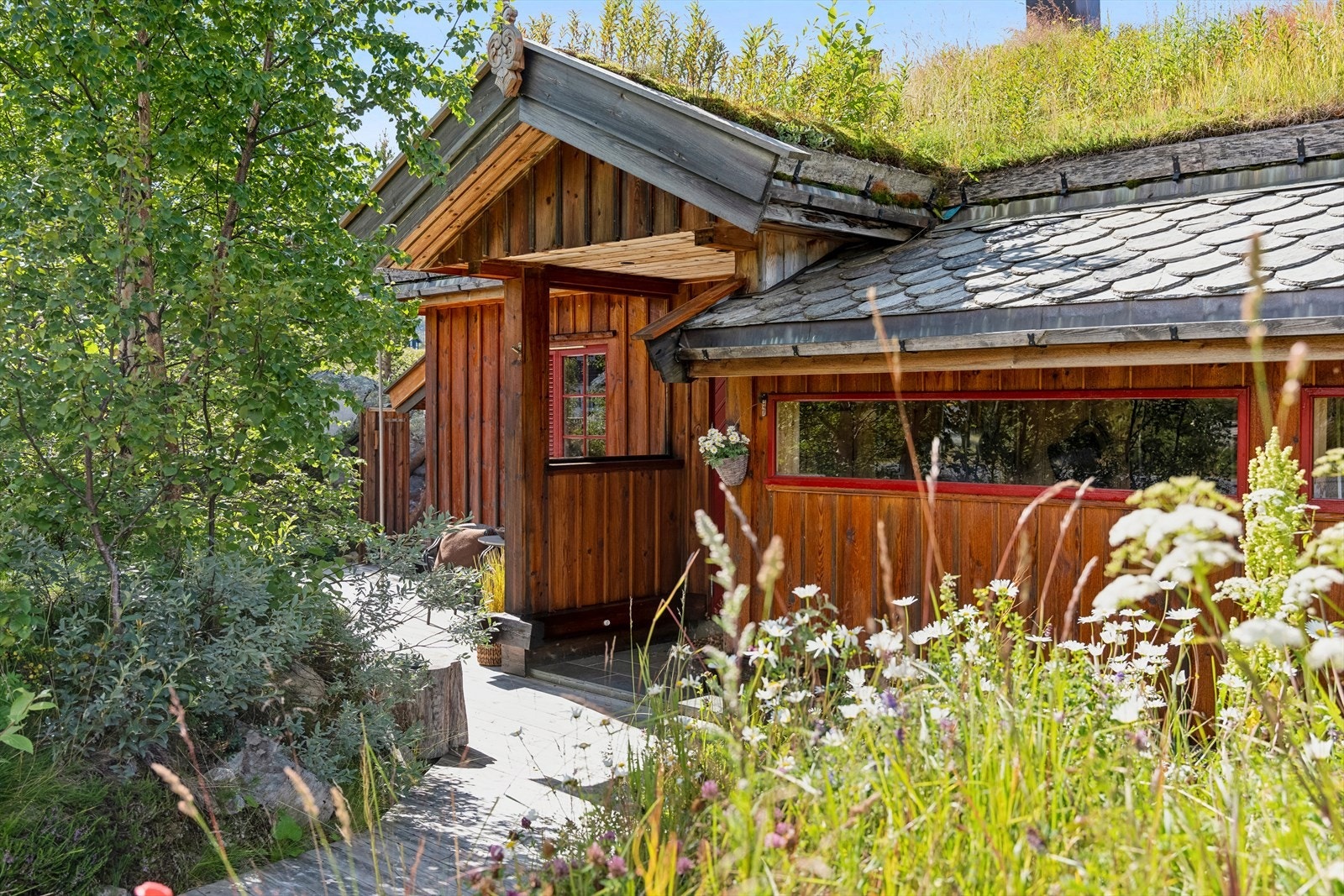 Inngangspartiet med overbygg og vakker skifer på taket. Hytta har flotte uteplasser rundt hele eiendommen, perfekt for å finne le i fjellheimen. Galleribilde